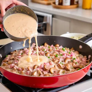 Рецепт Жюльен с грибами и ветчиной под сырной корочкой - Добавление ветчины и сливок